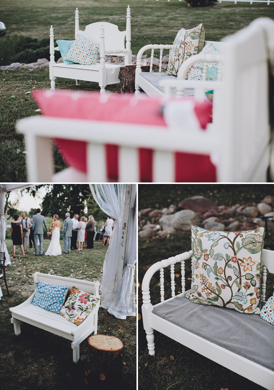 White wooden benches with colorful pillows at wedding