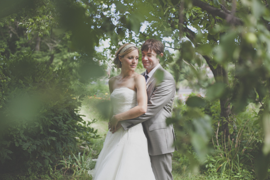 Wedding couple embraces in a lush green garden setting