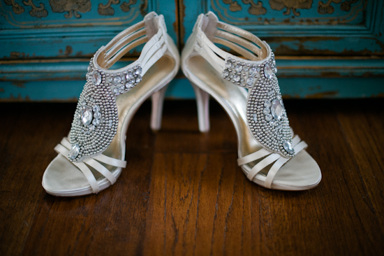 Elegant jeweled wedding shoes on wooden floor