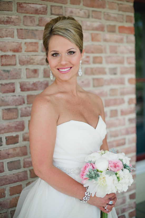 Beautiful bride in white dress holding a floral bouquet