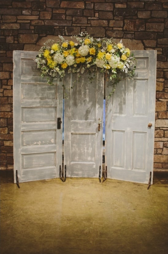 doors with yellow floral arrangement as a ceremony backdrop