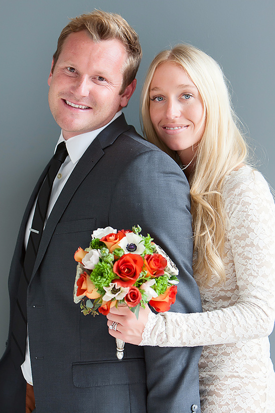 Happy couple in wedding attire with bouquet