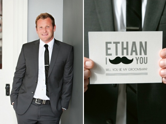 Man in suit holding groomsman card