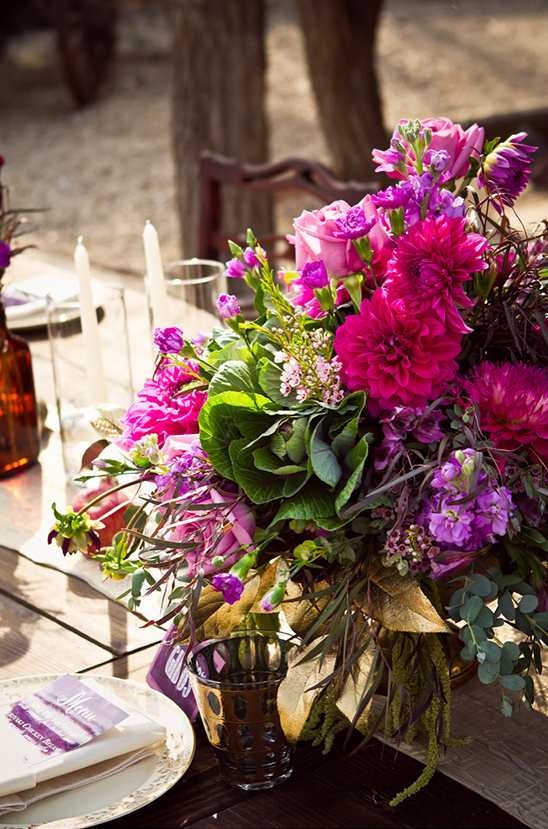 Pink and purple floral centerpiece on rustic table