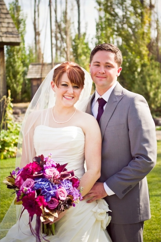 Happy couple in wedding attire with bouquet