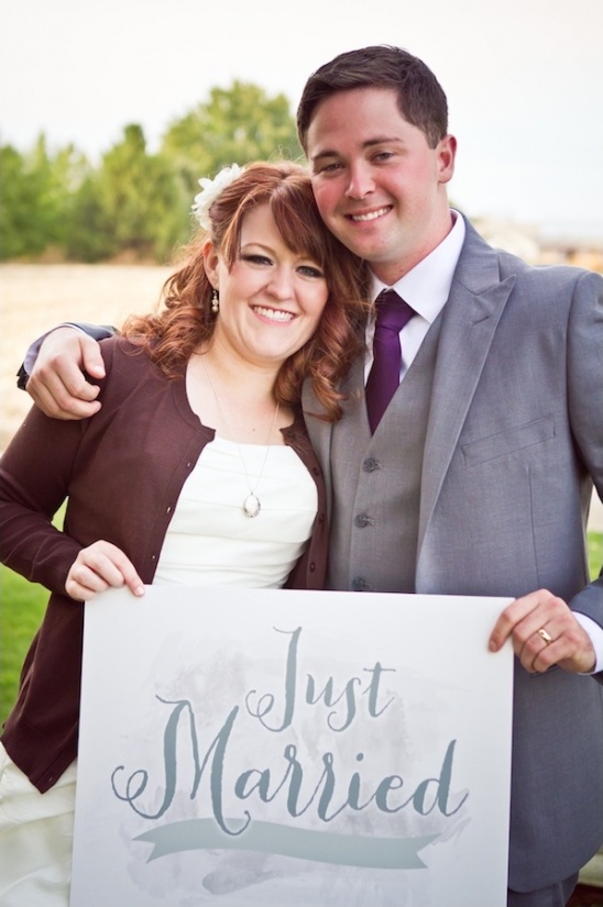 Happy couple holding Just Married sign