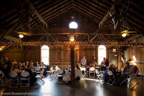 Rustic barn wedding reception with guests seated at tables