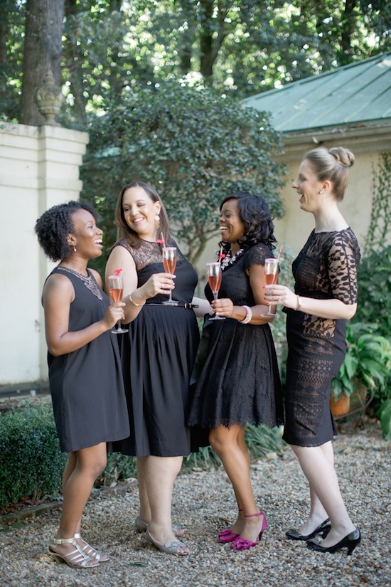 Happy women in black dresses toasting with champagne