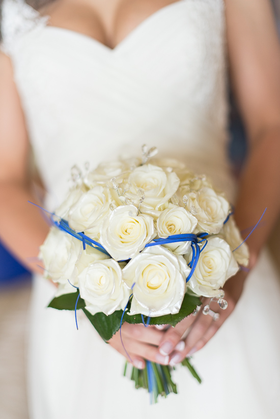 Bride in white dress holds rose bouquet