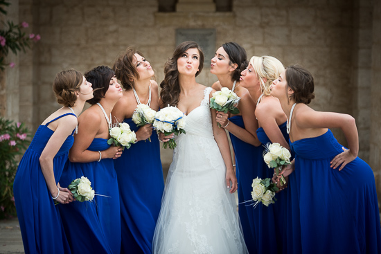 Bride with bridesmaids in blue kissing her