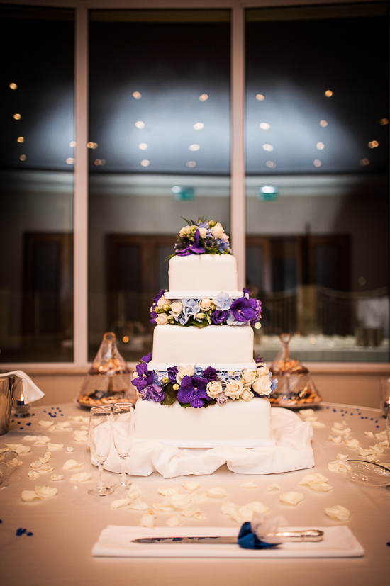 Four tier wedding cake with purple and white flowers