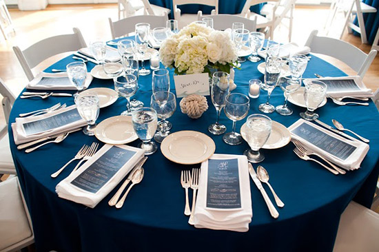 Elegant round table with navy blue tablecloth and decor