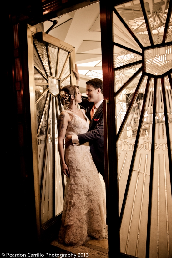 Romantic wedding couple embracing in ornate doorway