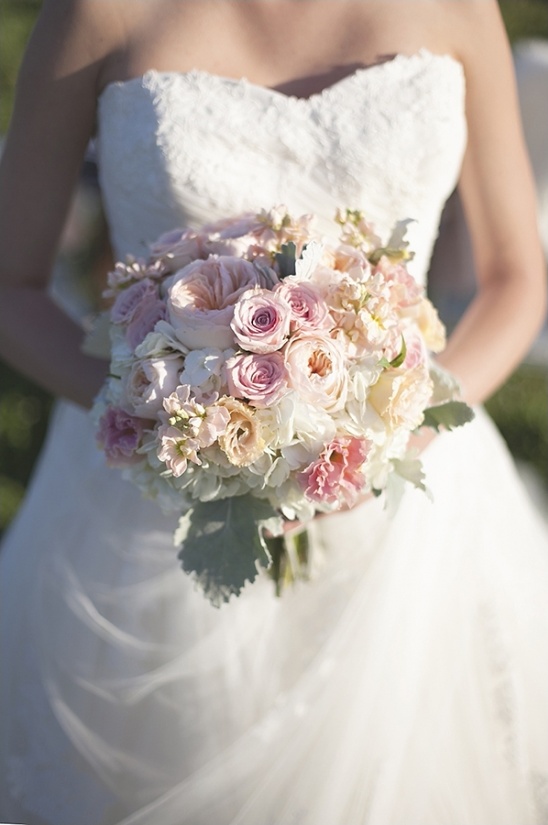Bride holding a delicate bouquet of pink and white wedding flowers