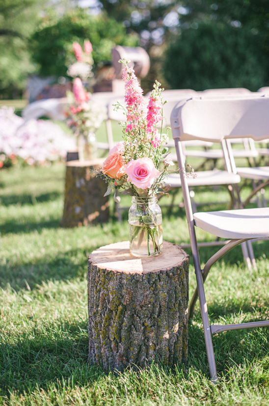 rustic stump and floral aisle decor