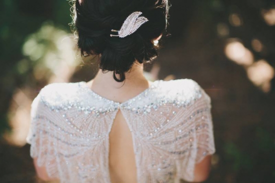 Bride in beaded gown with feather hairpiece