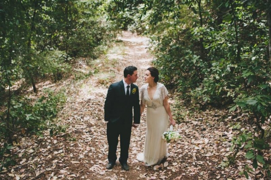 Happy couple in wedding attire, embracing in a forest