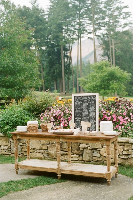 Wooden buffet table outdoors with seating chart