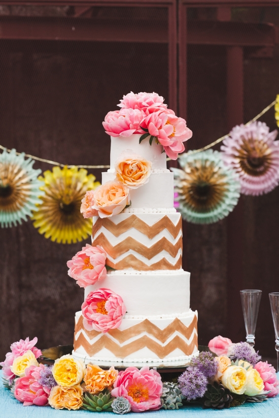 White cake with pink flowers and gold chevron design