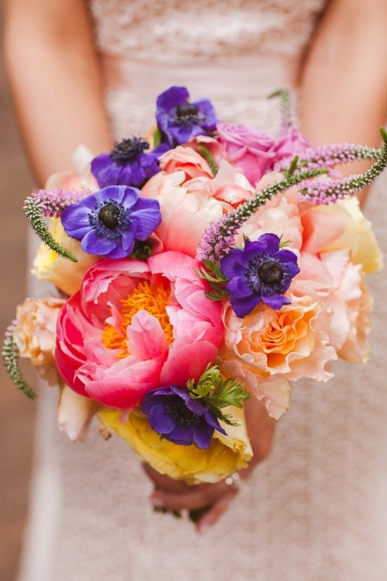 Bride holds vibrant bouquet of peonies and anemones