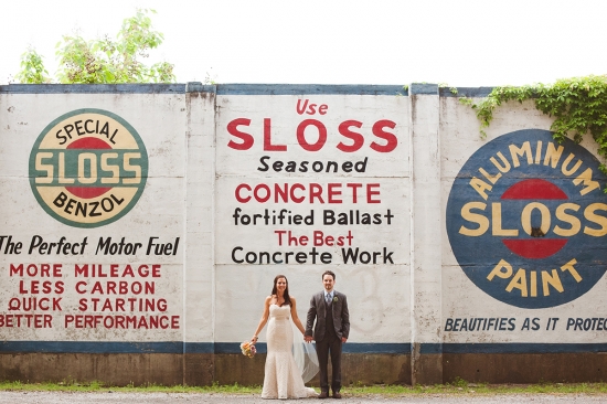 Bride and groom pose in front of a Sloss Furnaces mural