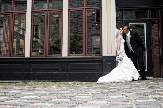 Couple kissing, wedding dress, stone street