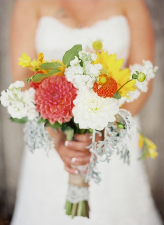 Bride holding colorful dahlia sunflower wedding bouquet