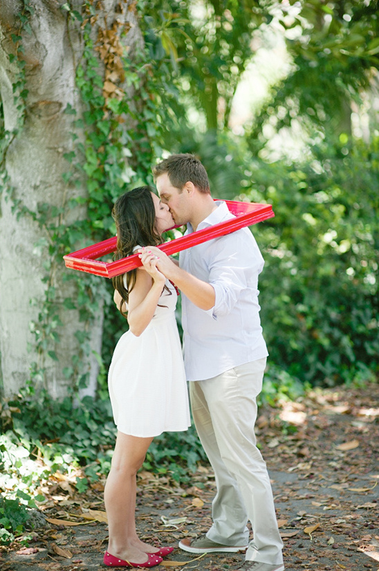 Couple kissing framed by red picture frame