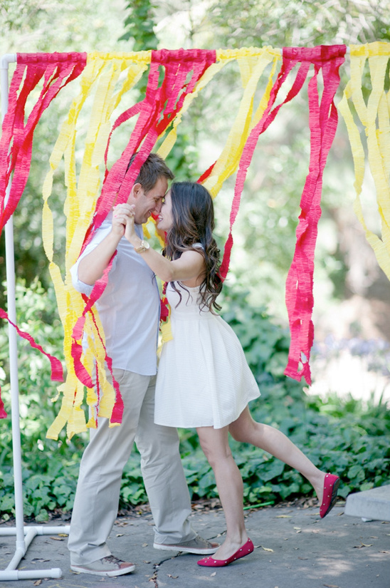 Romantic couple embracing behind colorful streamers