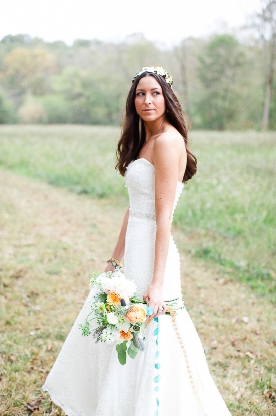 Bohemian bride in a white dress holding a beautiful bouquet of flowers