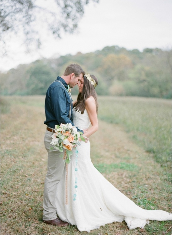 Couple embracing in a field during a romantic outdoor wedding ceremony