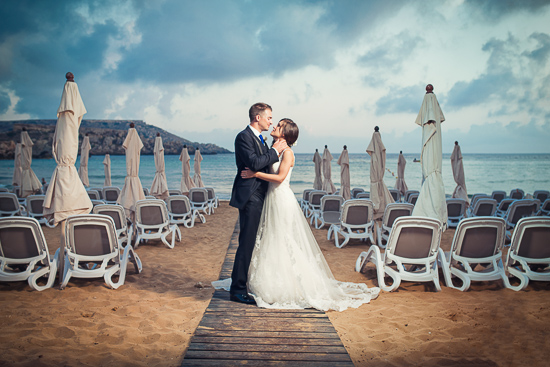 Beach wedding bride and groom embrace lovingly