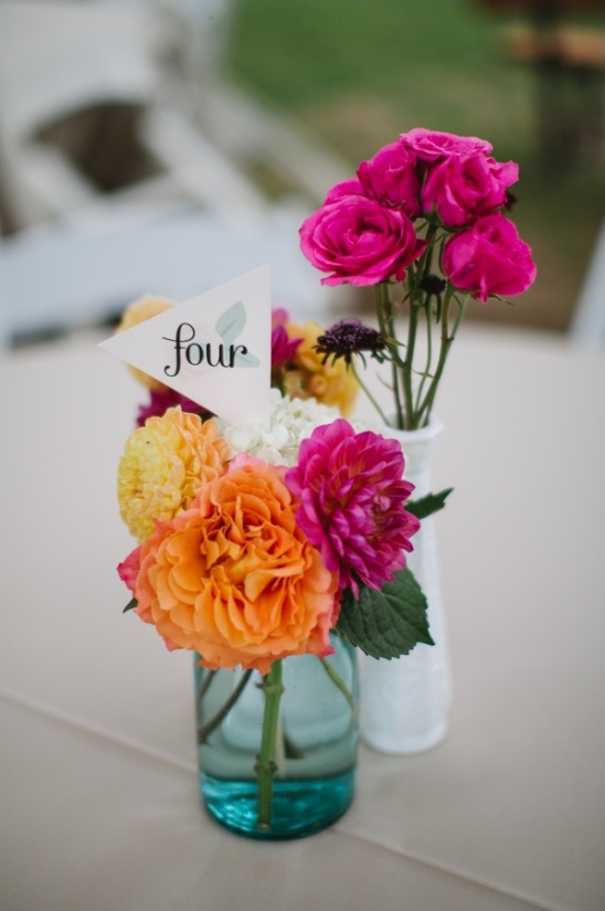 table number flags with hot pink and orange centerpiece florals