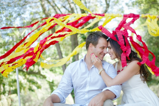 Smiling couple with red and yellow streamers above them