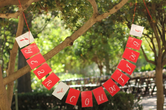 Outdoor wedding decor red white banner strung on tree