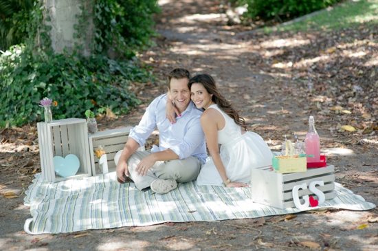 Happy couple enjoying picnic in sun dappled woods