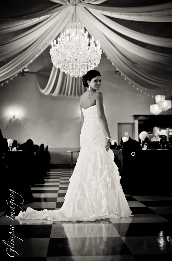 Bride in white dress under chandelier black and white