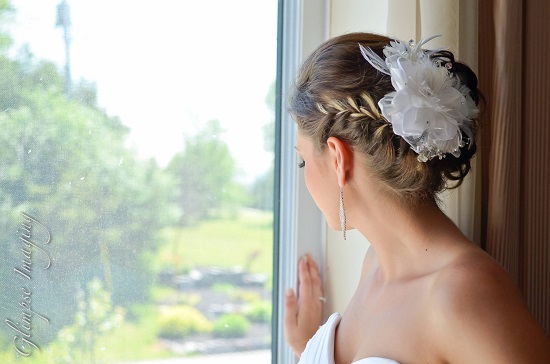 Bride looks out window with elegant updo hairstyle