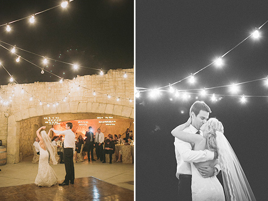 Wedding couple dancing under string lights at a night reception