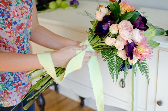 Woman tying ribbon on a beautiful flower bouquet