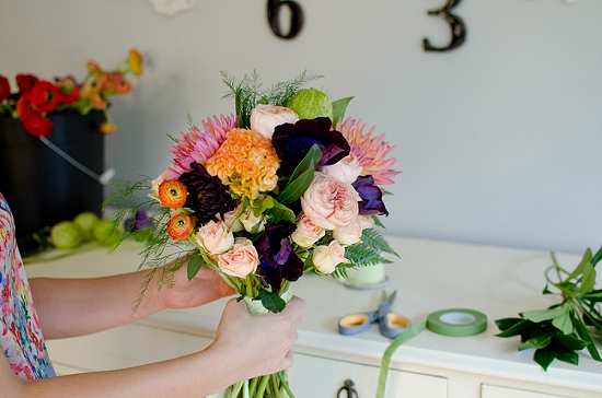 Hands holding colorful flower bouquet being arranged