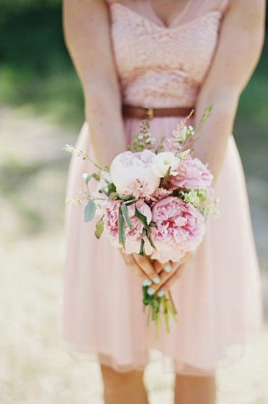Woman in a pink dress holding a bouquet of pink flowers for a wedding