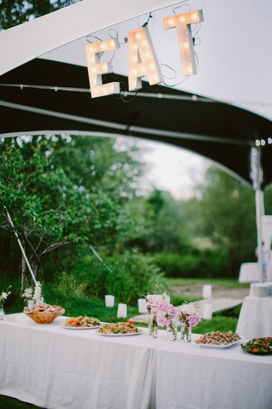 Outdoor dining table with EAT sign and delicious food ready