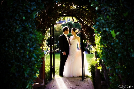 Couple in wedding attire garden archway