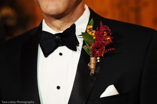 Groom in tuxedo with boutonniere and black bow tie
