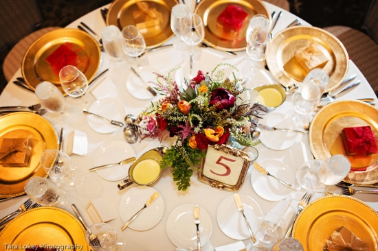 Elegant wedding table setting with gold chargers flowers