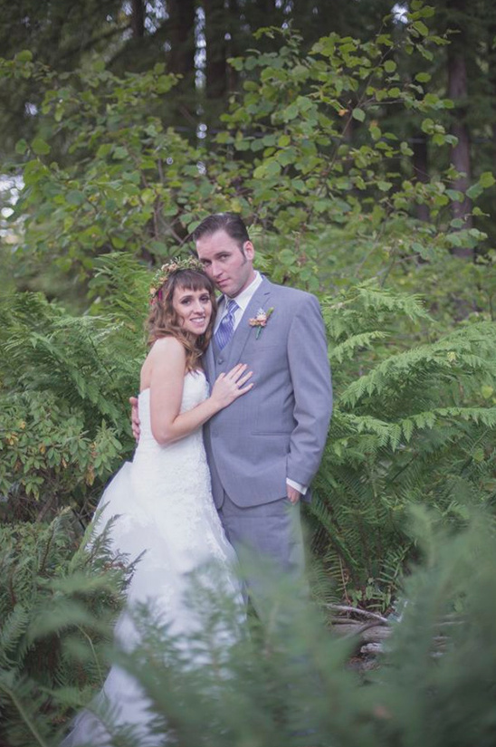 Bride and groom pose in a forest on their wedding day
