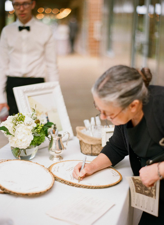 Guest signing wooden wedding guestbook