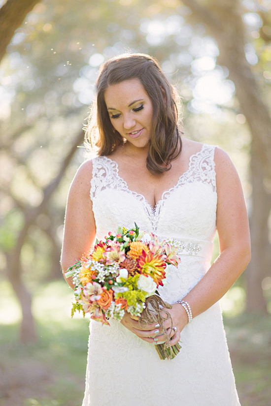 Beautiful bride holding colorful bouquet, looking happy on wedding day