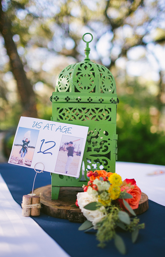 Green lantern with photos and flowers on a table centerpiece